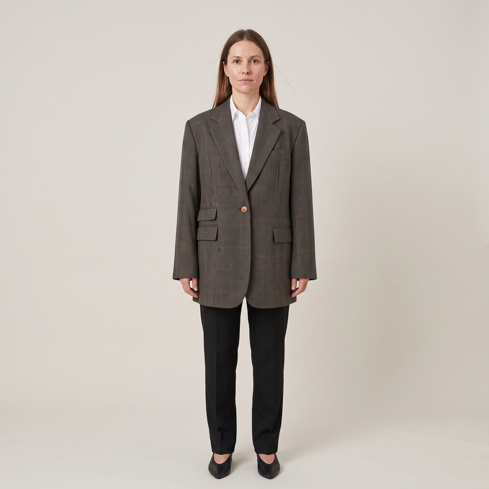 Blazer oversize Ambre à carreaux marron fermé par son bouton bois sur une chemise blanche, de face